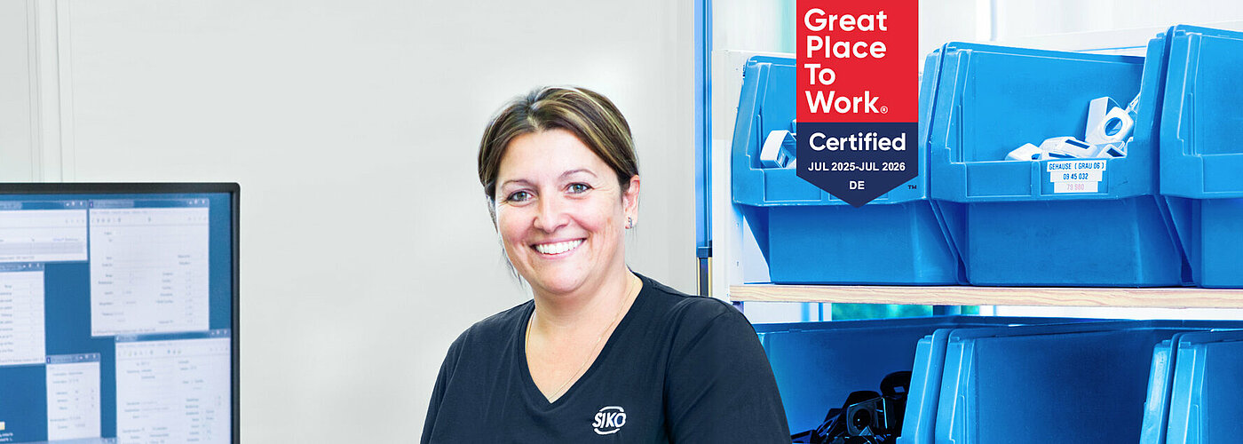 SIKO Mitarbeiterin in der Produktion vor blauen Lagerbehältern